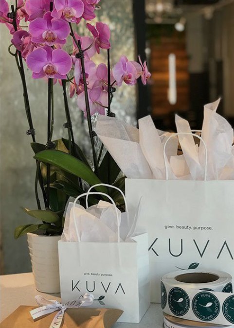KUVA gift bags and stickers beside pink orchids