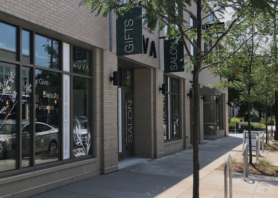 The KUVA storefront with its Gifts and Salon signs and botanical window graphics