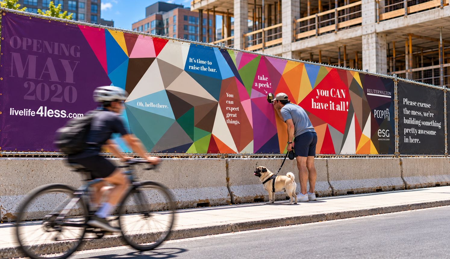 A Marquee construction fence banner with a cyclist riding past